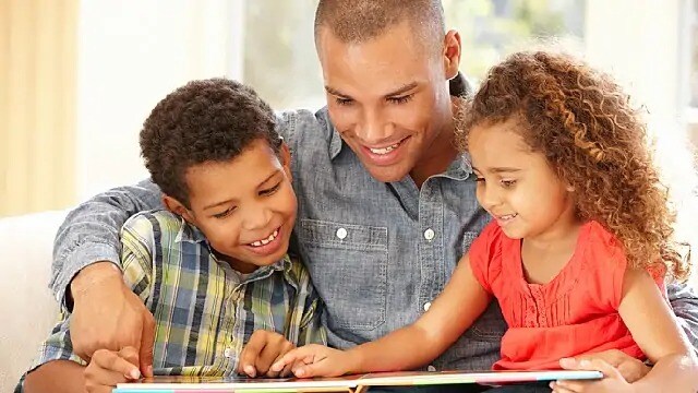 Man reading a book to toddlers