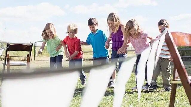 Six children running a 3 legged race