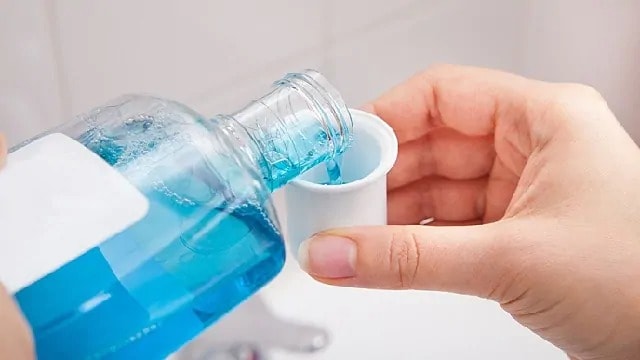 Mouthwash being poured into a cap