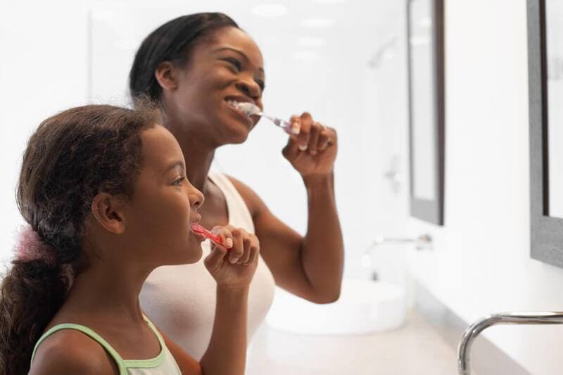 parent showing child proper oral health habits