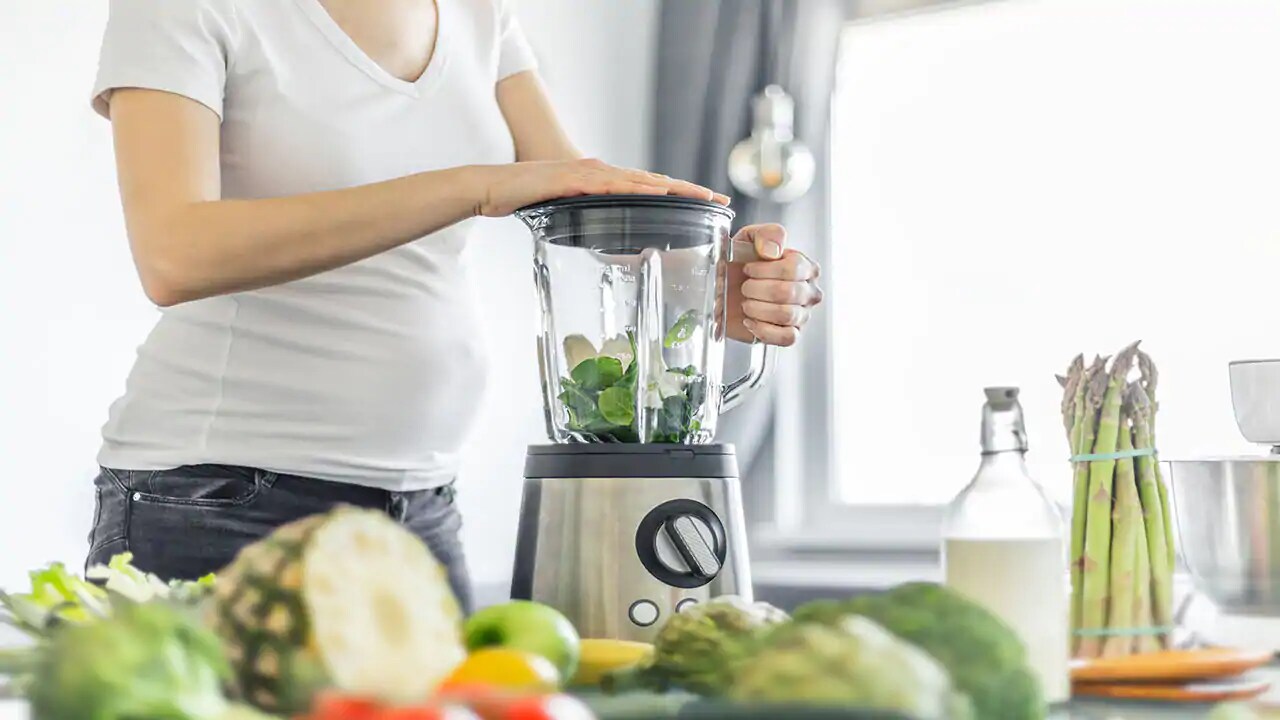 pregnant woman making smoothie with folic acid