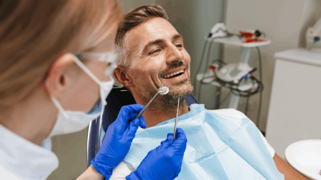Happy man sitting in dental chair ready for treatment