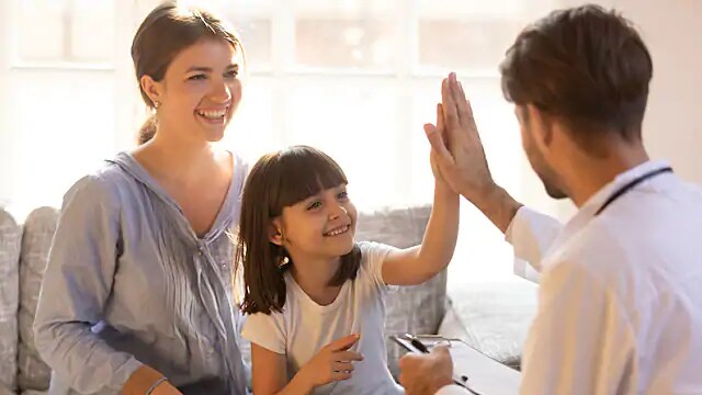Child & Dentist Smiling after Successful Dental Cleaning