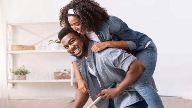 man is giving a piggyback to woman in living room
