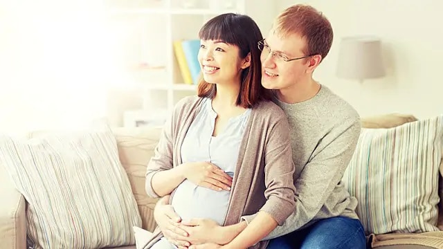 expecting mother and father discussing teeth whitening with dentist
