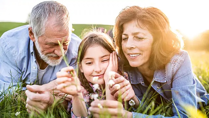 grandparents smiling with granddaughter