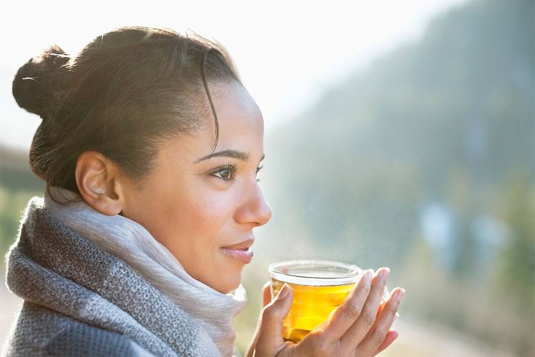 a young woman is drinking green tea to avoid bad breaht