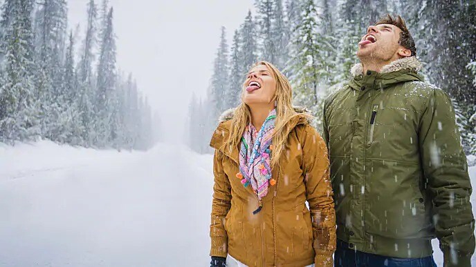 woman with healthy tongue catching snowflakes
