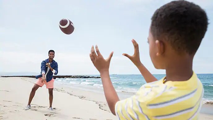 father and son playing football