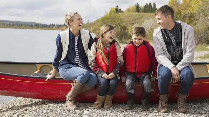 family smiling together on canoe