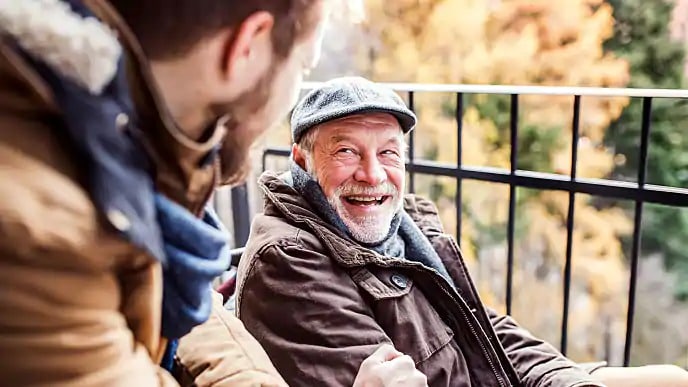older man smiling outside