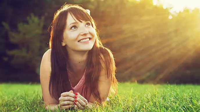 woman laying outside after teeth whitening treatments