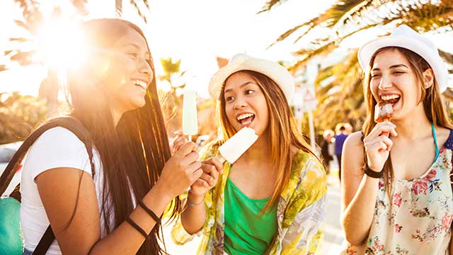 Teenager girls eating an ice cream outside in the summer