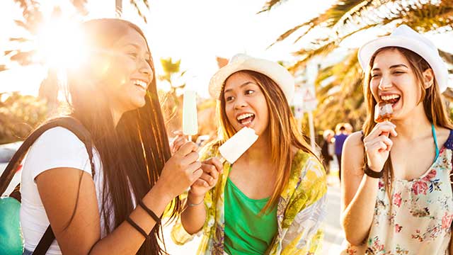 Teenager girls eating an ice cream outside in the summer Teenager girls eating an ice cream outside in the summer