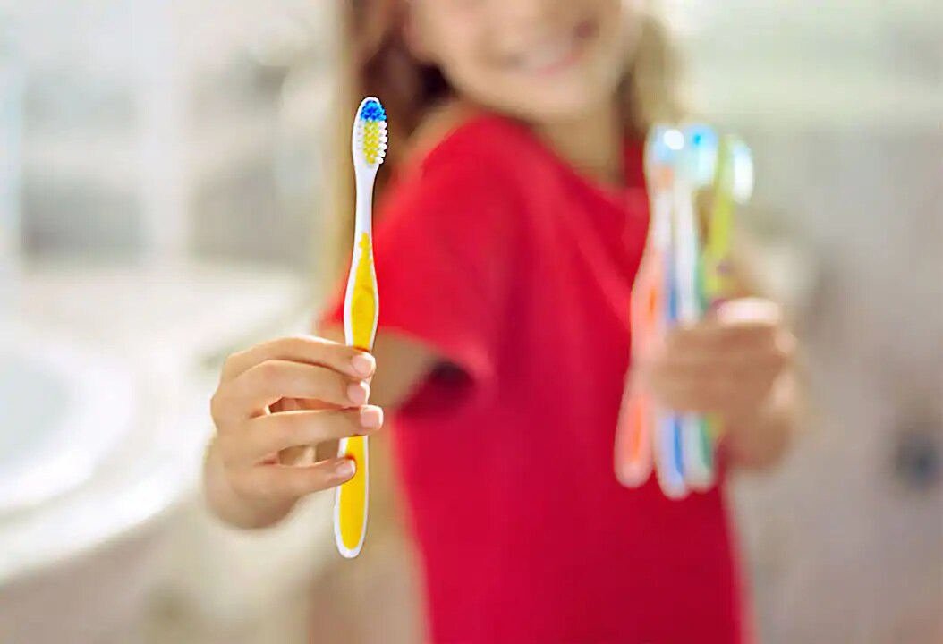 young girl is donating unused toothbrushes