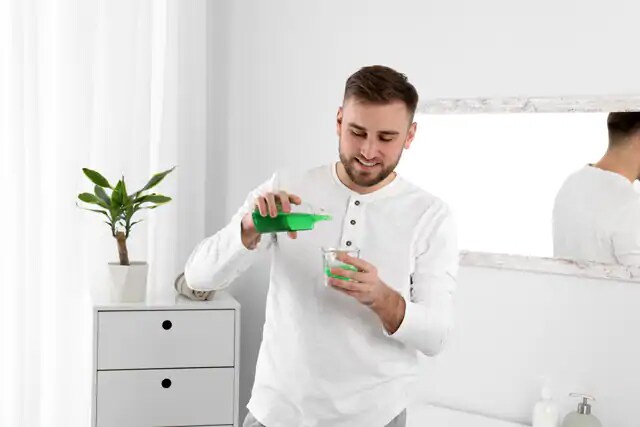 man using chlorhexidine gluconate oral rinse