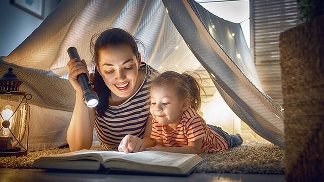 Madre leyéndole un libro a su hija