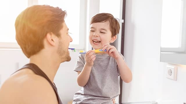 Padre e hijo cepillandose los dientes