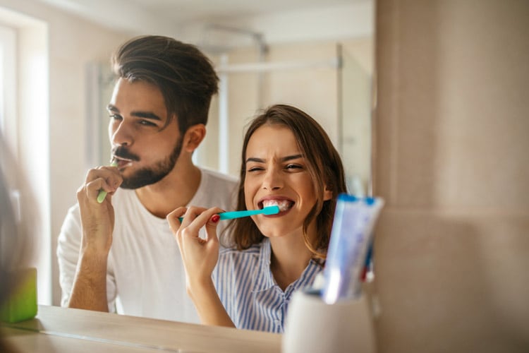femme souriante utilisant des produits dentaires colgate