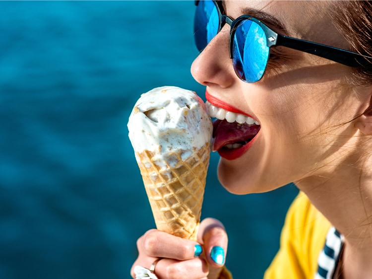 Femme mangeant sa glace et souriant