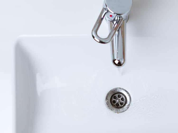 water running down the drain of a sink