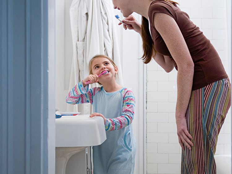 girl being taught importance of brushing teeth