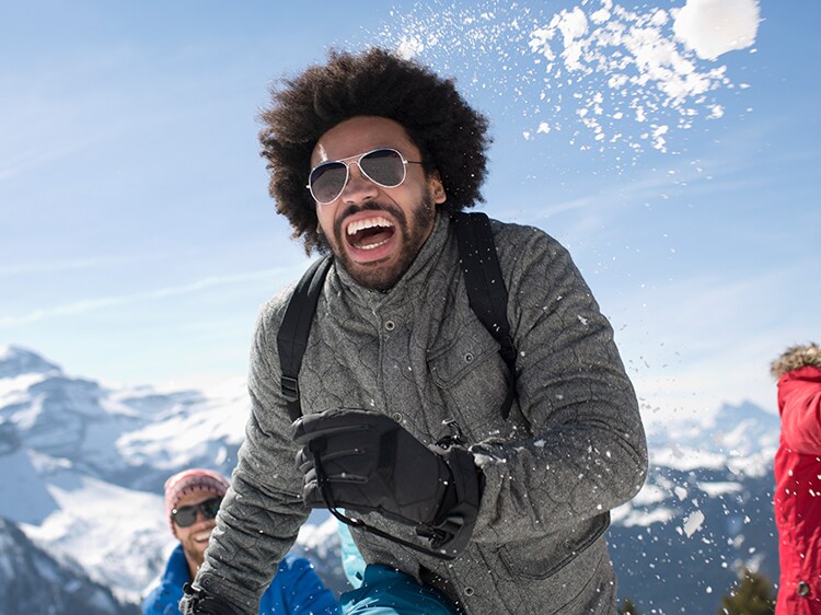 man smiling while playing in snow