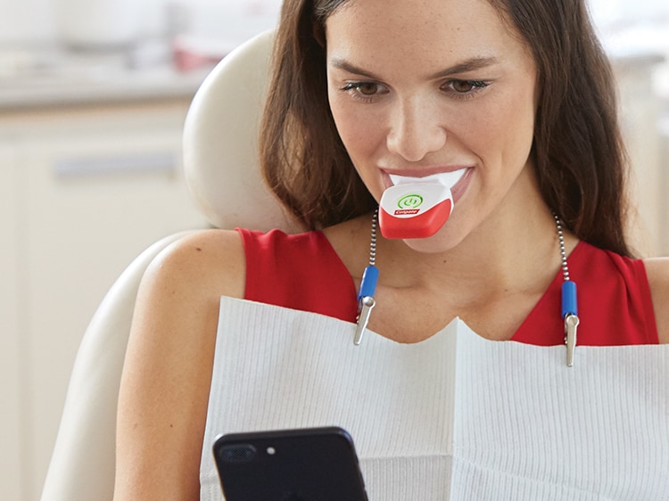 woman using colgate teeth whitening device