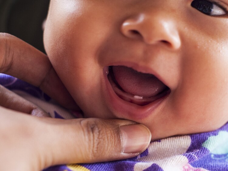 infant with emerging baby teeth