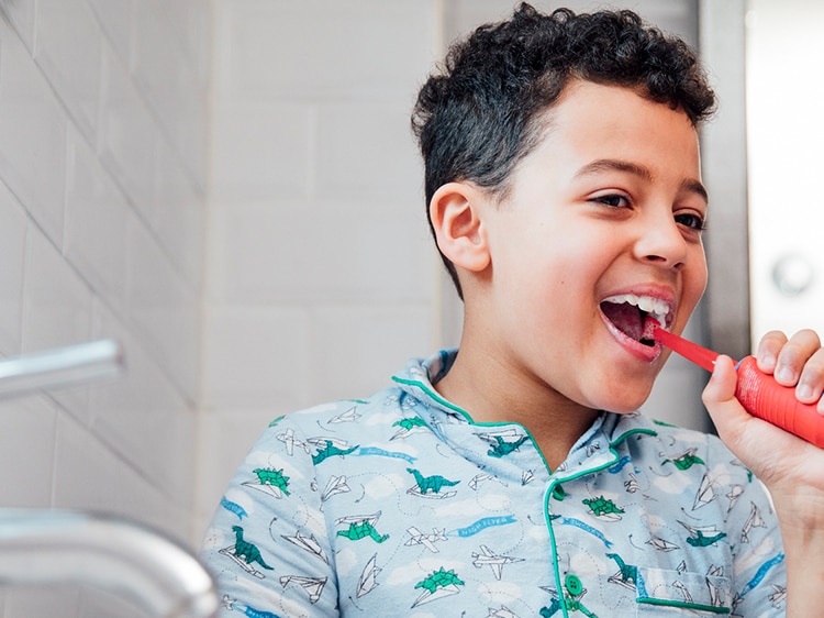 boy brushing teeth with colgate toothbrush