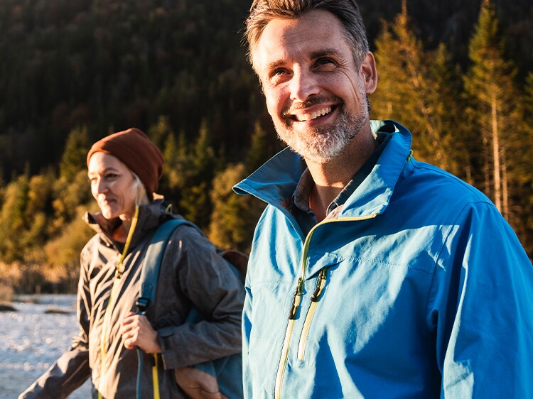 smiling couple hiking in the woods