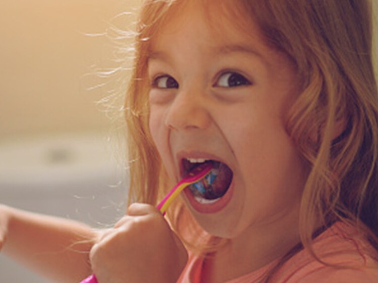 toddler brushing their teeth with colgate toothbrush
