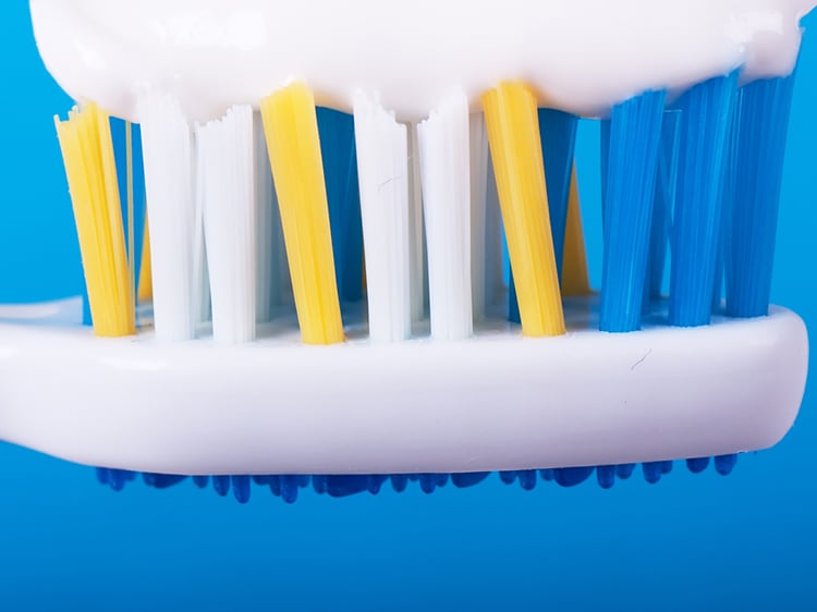 close up of colgate toothpaste on toothbrush