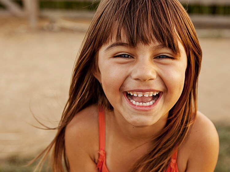 young girl smling showing growing teeth