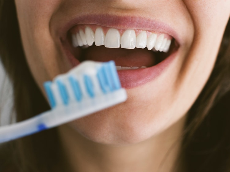 smiling woman using colgate dental products
