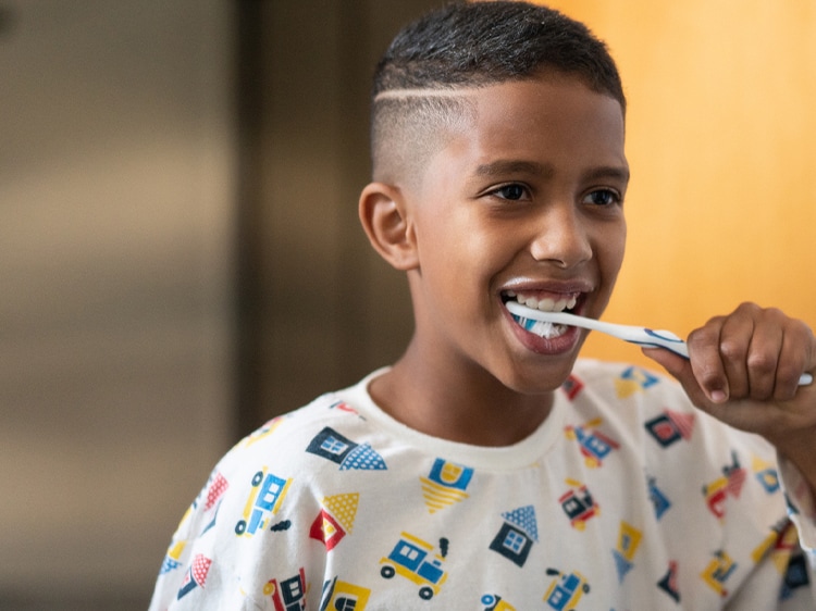 Mixed race girl brushing teeth.