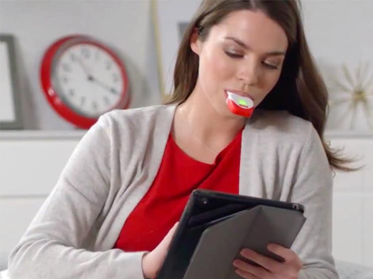 woman using colgate optic white teeth whitener