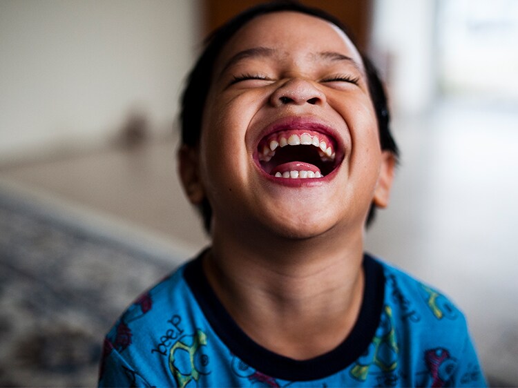 toddler laughing with eyes closed