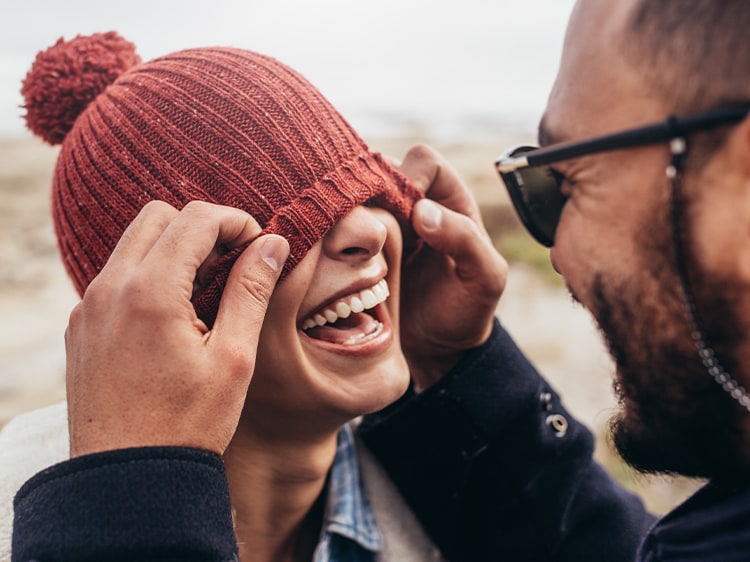 couple playing with woman's hat