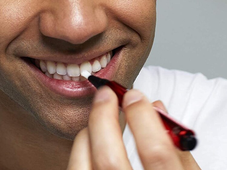 man using colgate tooth whitening pen