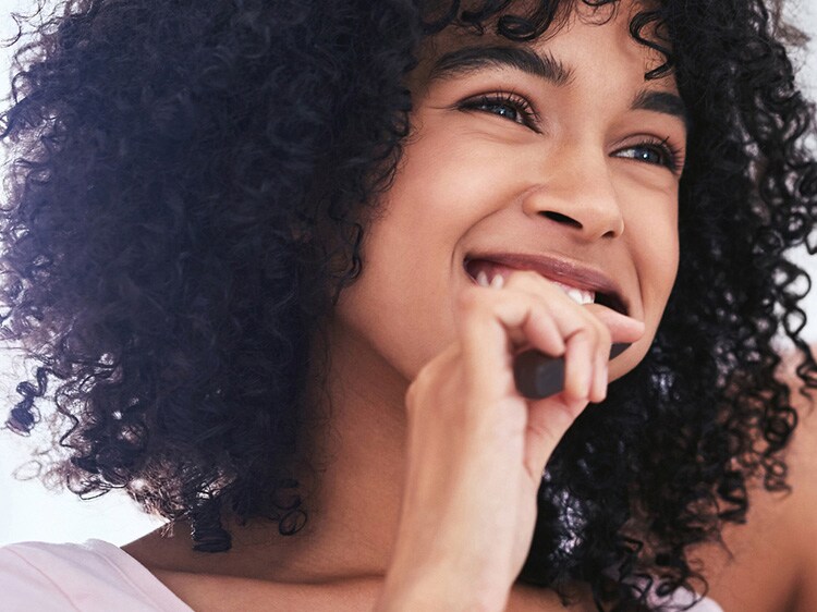 woman using colgate charcoal toothbrush