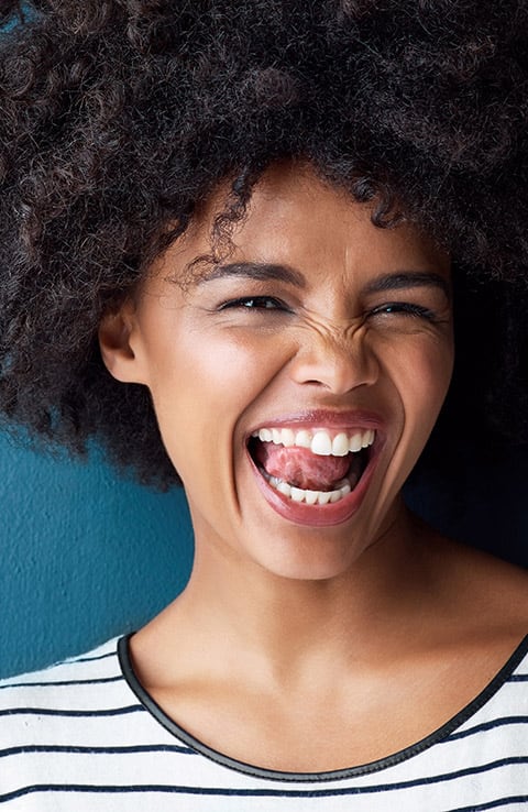 smiling woman licking her white teeth 