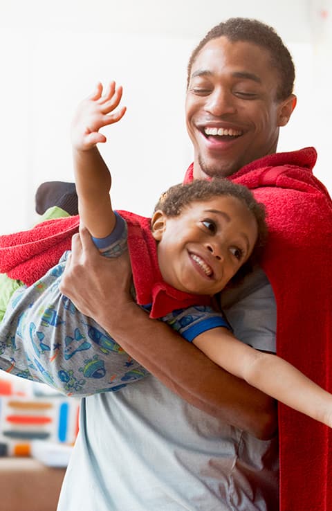 Hombre jugando con niño a los superheroes