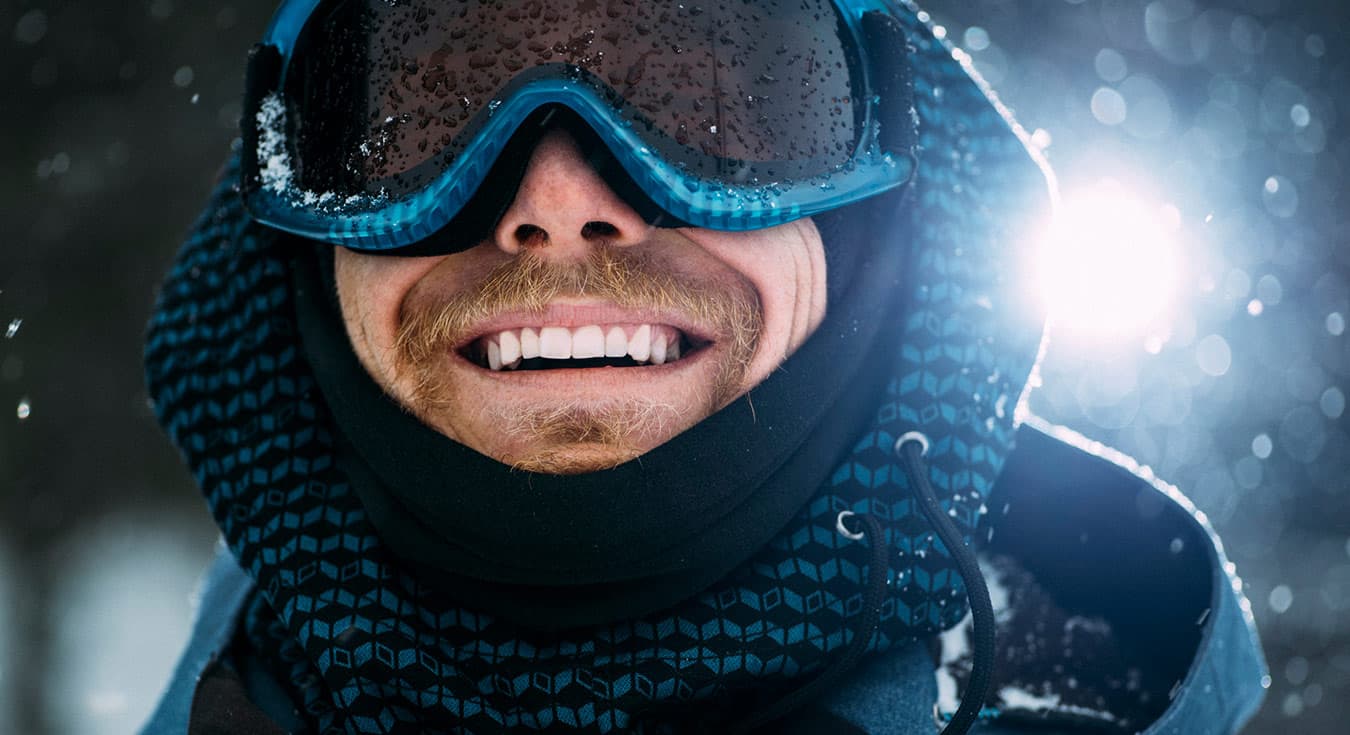 man wearing snow goggle smiling brightly