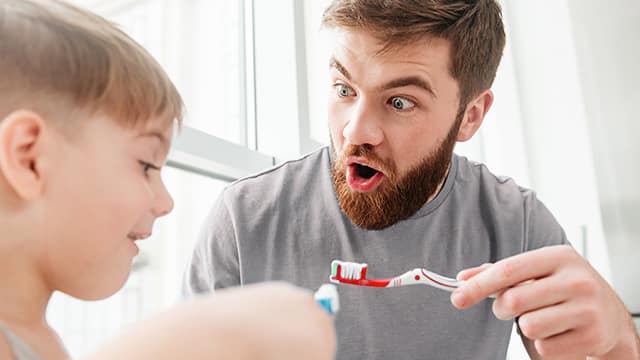 hijo y padre cepillandoce los dientes