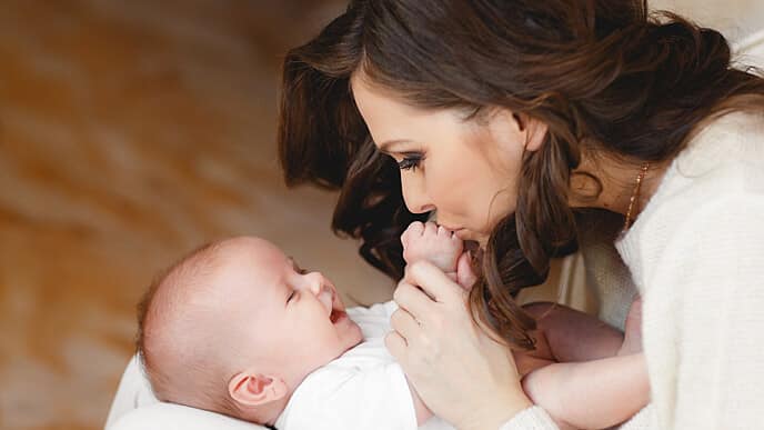 madre besando manos a su bebé
