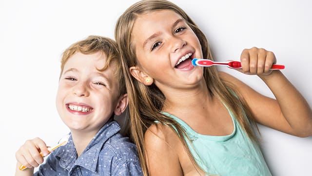 niños riendo con cepillo dental