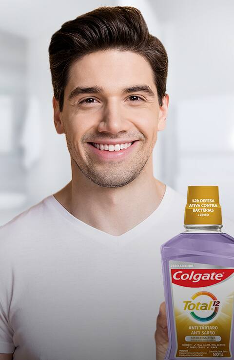 pareja sonriendo mientras usa cepillos de dientes colgate