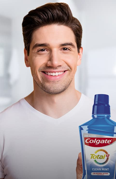 pareja sonriendo mientras usa cepillos de dientes colgate