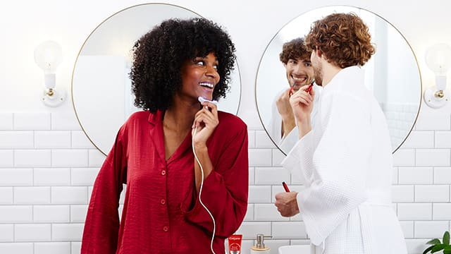 Young woman and man using teeth whitening kits